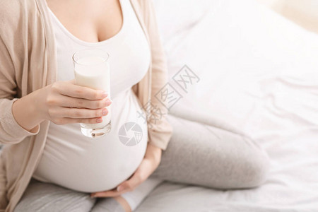 健康营养和怀孕的概念孕妇的腹部和一杯鲜图片