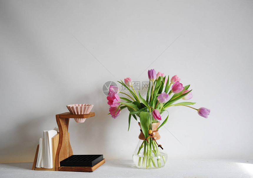 花郁金香花束在白色桌子上的咖啡滗水器用日本陶瓷折纸滴头手动冲泡木制图片
