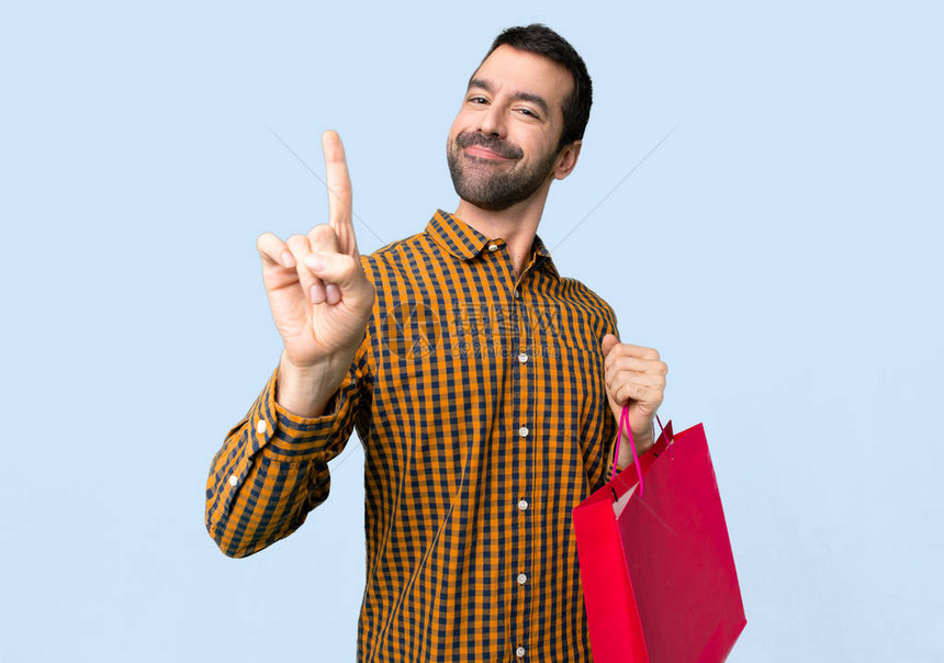 男人用购物袋展示和举起一根手指图片