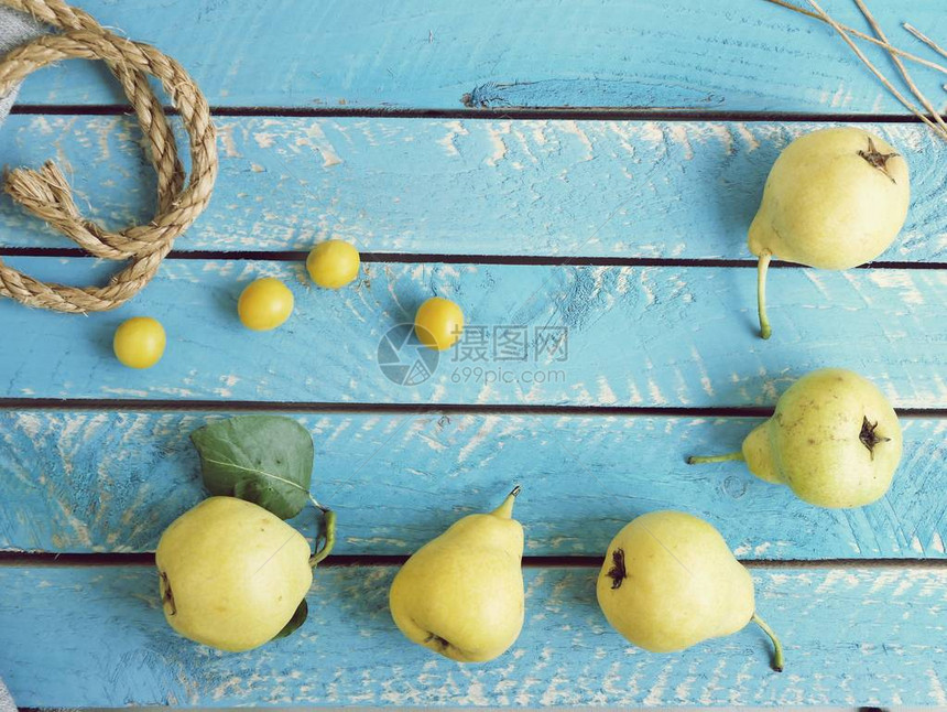分布在蓝色木制桌上的黄熟梨子和李子顶部视野夏季概念收图片
