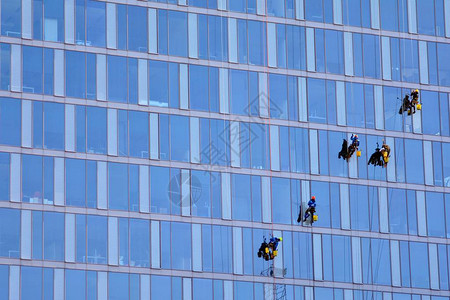 攀爬者清洗摩天大楼的窗高清图片