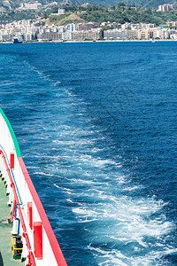 横跨墨西拿海峡的渡轮船尾端和背景中墨西纳市的海景垂直视图图片