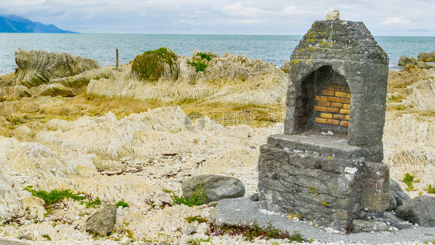 Kaikoura不寻常的沿海地貌是白色分层沙石和旧壁炉残骸图片