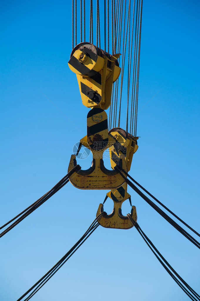 在港口装货在蓝天背景的浮动港口起重机带吊索的链子和钩子吊机图片