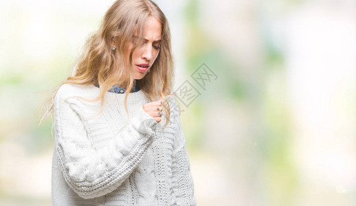 穿着冬毛衣的美丽的金发年轻女子在孤立的背景中感到不舒服和咳嗽图片