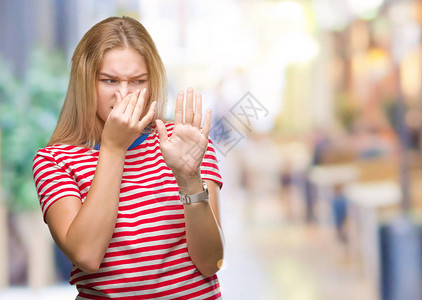 年轻的白种女人在与世隔绝的背景下闻到某种臭味和恶心难以忍受的气味图片