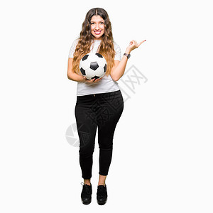 年轻成年女子拿着足球图片