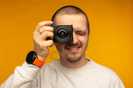 男人把相机放在他的眼睛上带无反光镜相机的摄图片