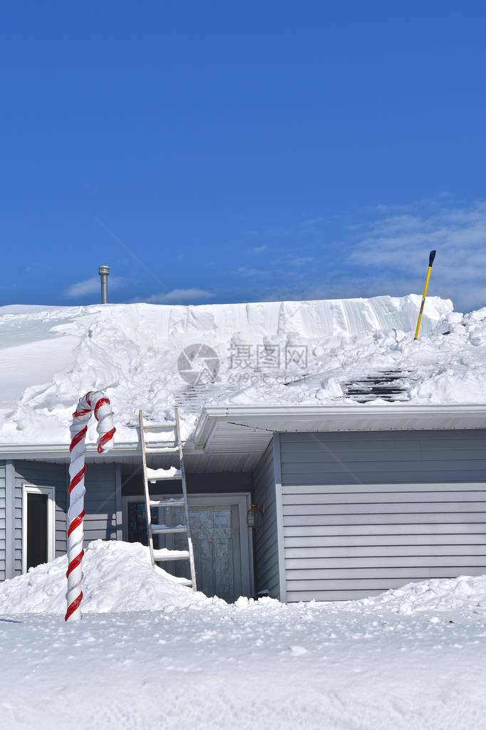 大雪过后正在用铲子从屋顶上除雪图片