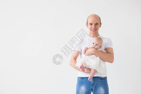 育儿家庭和父亲的概念秃头父亲抱着他的小婴儿女在白色背图片