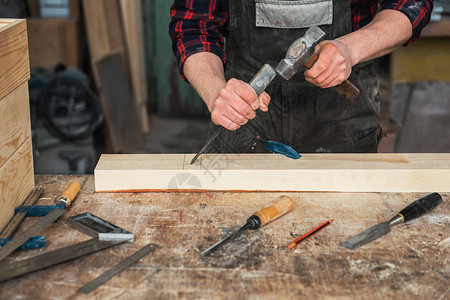 木匠在木制车间里用凿子和锤子工作专业木工和手图片