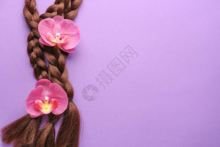彩色背景上的编织线和花朵头发捐赠的概念图片