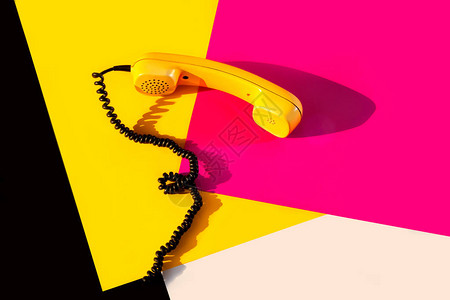 黄色和粉红色背景上的黄色老式手机紫色黑色和橙色背景的复古电话迪斯图片