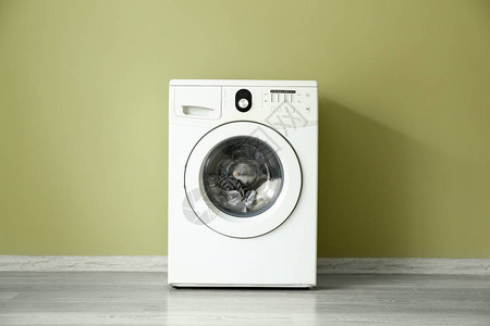 靠近彩墙的现代洗衣机背景图片