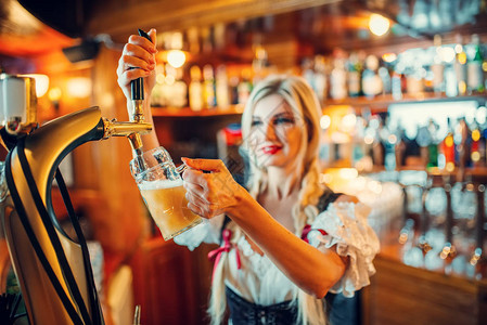 感女服务员在酒吧的柜台把啤酒倒到一个杯子上图片