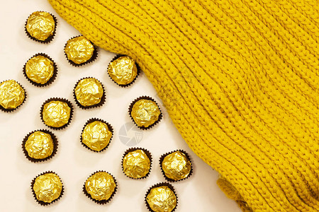 羊毛冬季围巾下的金色高级巧克力糖果图片