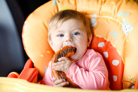 可爱的小女婴吃面包孩子第一次吃椒盐卷饼母乳喂养后的第一餐健康图片