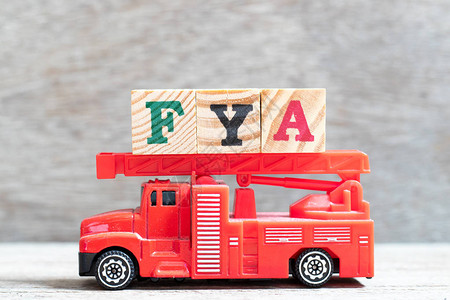 红色消防车在木材背景上用FYA字封住字母块为您的行动或图片