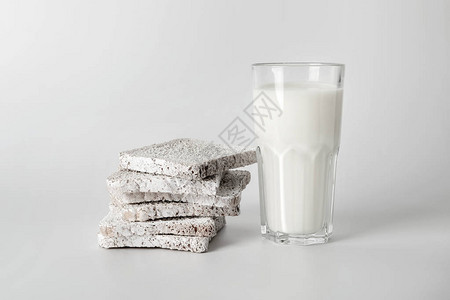 白色背景上的一叠面包片和一杯牛奶图片