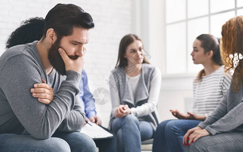 心理治疗抑郁症生活问题概念抑郁的人坐在康复小组治疗中背景图片