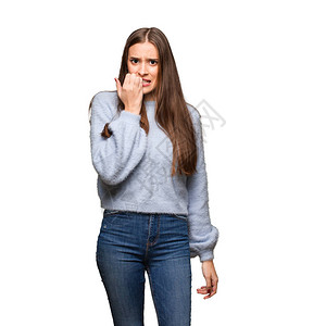年轻的caucasian年轻女人咬指甲紧图片