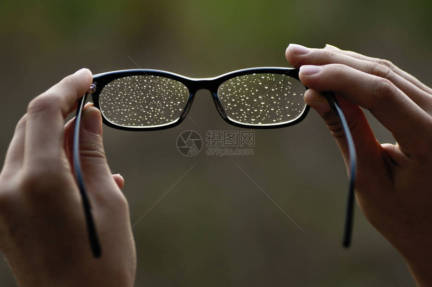 眼镜与水滴在女人手中图片