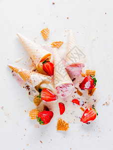 白色背景的碎裂和溢出奶油草莓和图片