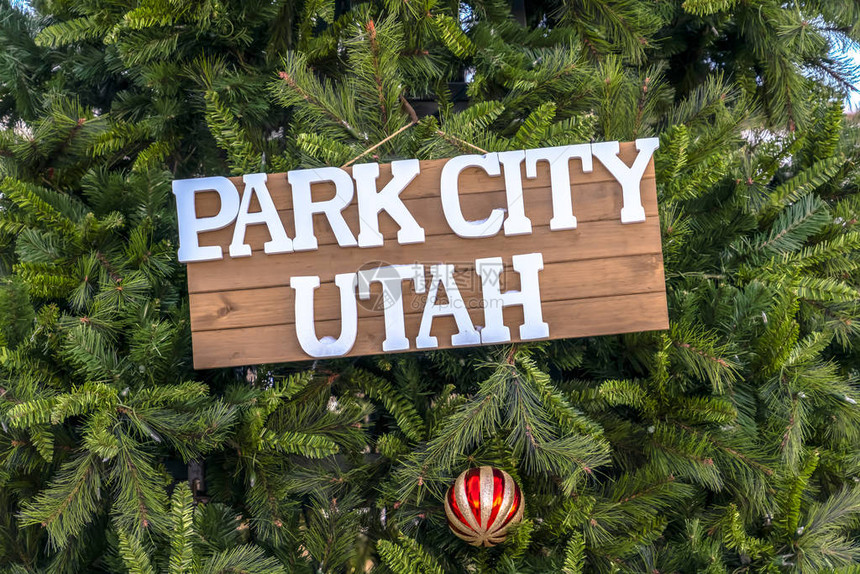 帕克城犹他州标志和圣诞树上的小玩意关闭一个木制的帕克城犹他州木牌和挂在圣诞树上的闪亮的小玩意滑雪胜地的户外假日图片