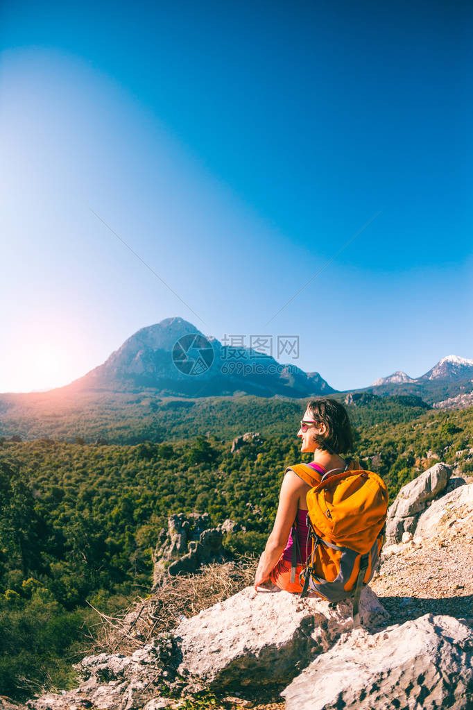 山顶的女孩一个背着包的女人走在山路上爬到顶部前往风景如画的地方反对天空的旅游土耳其风景图片