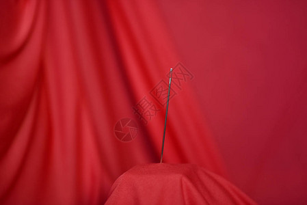 红布背景上的钢制裁缝针图片