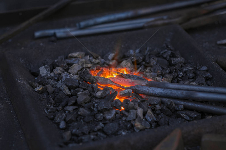 铁匠用火花烟手工锻造铁砧上的熔融金属图片