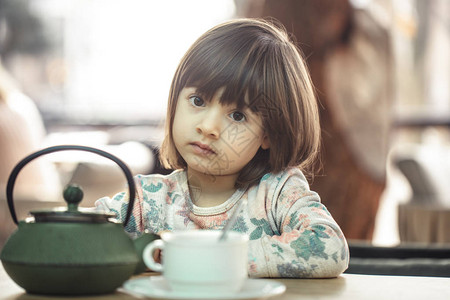 在咖啡馆的可爱小女孩喝茶和图片