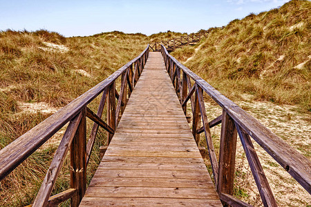 木质的步行道有海沙丘美丽的天空和山丘麦斯奎达梅图片