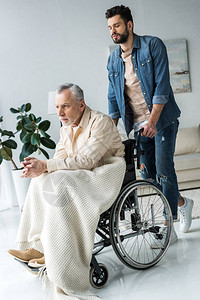 家里持残疾老年父亲轮椅的英俊长图片