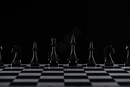 棋盘上黑色的棋子被隔离在黑色上图片