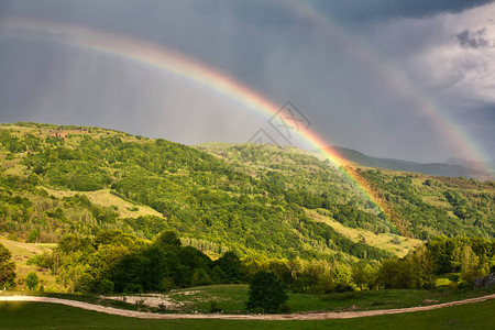 夏季有绿色的山丘和巨大的彩虹图片