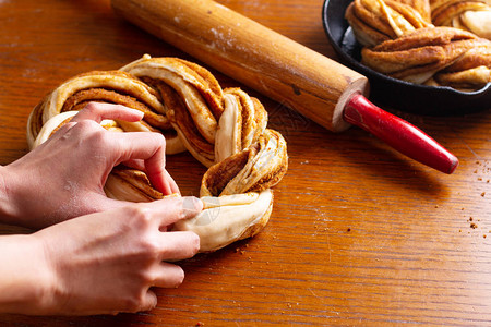 食品烘焙概念为肉桂卷编织面包制作带有复制高清图片