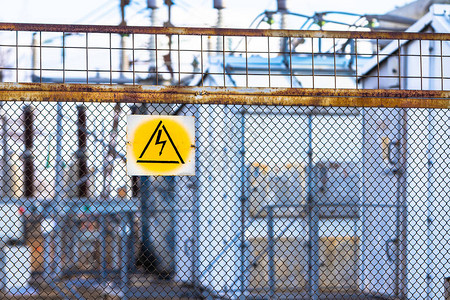 电线变电站周围的网栅上挂着高电压悬吊的危险信号警告单图片