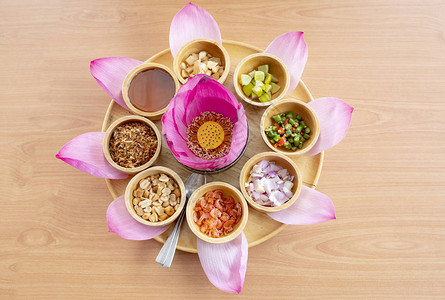 粉红莲花瓣装饰是明木桌上的泰国小吃图片