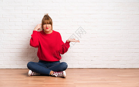 红发女人坐在地板上做疯狂的手势用手图片