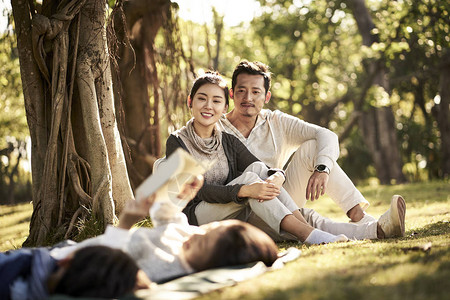 两个亚洲儿童小男孩和女孩躺在草地上玩得开心图片