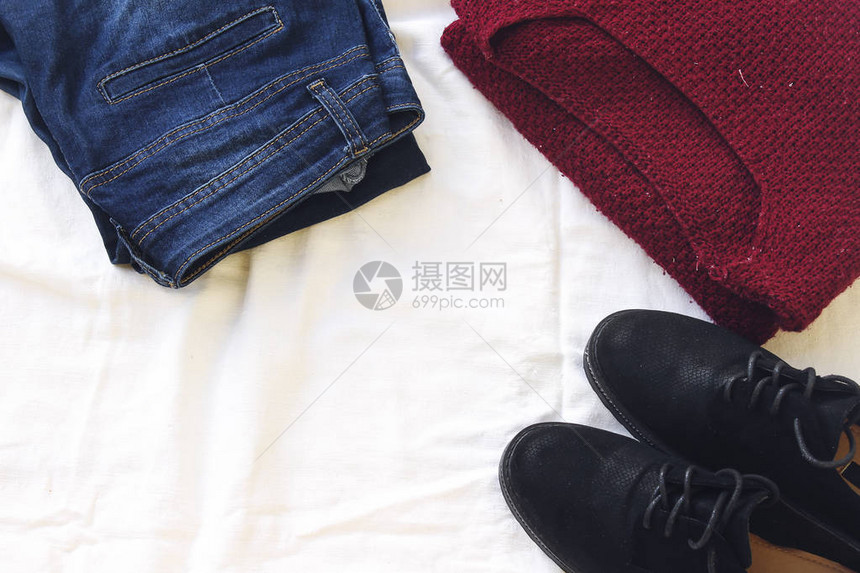 蓝色牛仔裤红色的超大编毛衣和白纸上的黑色平底鞋图片