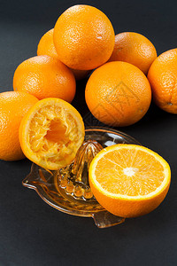深色背景中带橙子的手动榨汁机图片