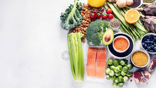 健康食品的选择清洁饮食概念用鱼超级食物蔬菜朝鲜蓟抱子甘蓝水果豆类和蓝莓烹饪食材全景背景图片