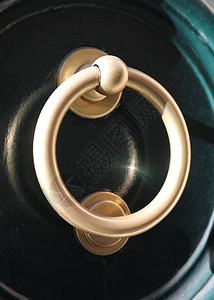 深绿色门上的黄铜金属门环图片