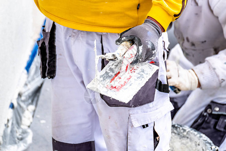 建筑工人用水泥抹灰和抹平混凝土墙图片