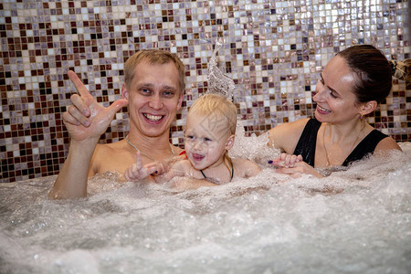 家庭幸福快乐在温泉中心放松在游泳池图片