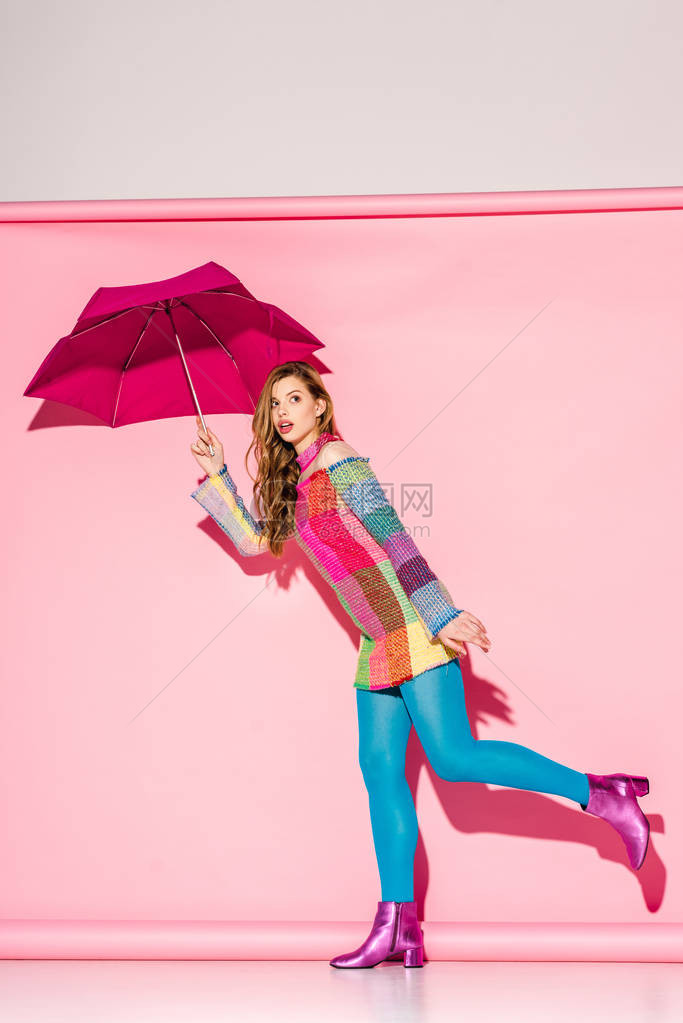 穿成格子装的年轻女人拿着雨伞图片