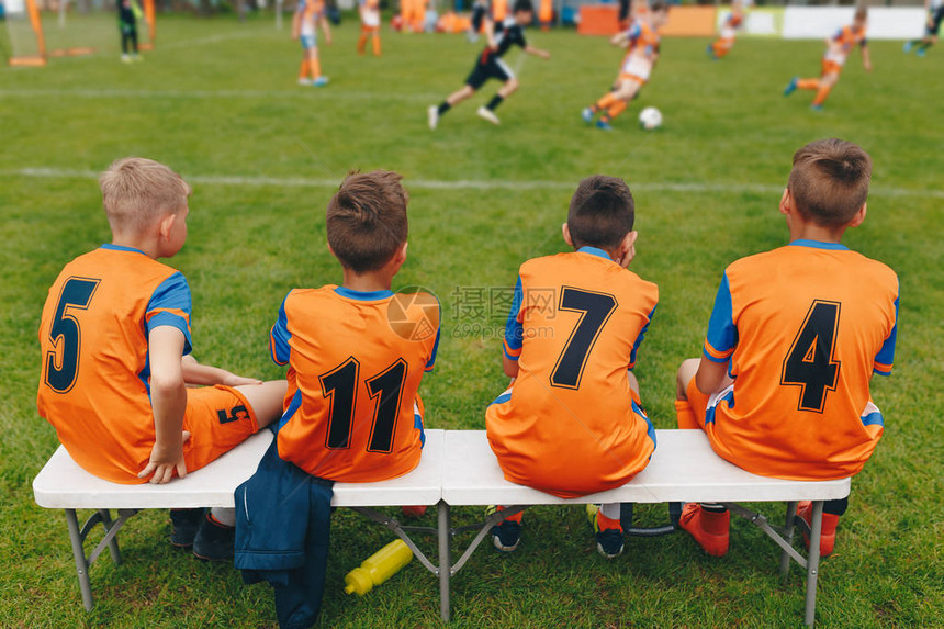 男孩足球队坐在板凳上儿童足球队员儿童足球比赛踢欧洲足球比赛的年轻男孩儿童足球学图片