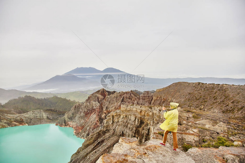 火山顶上有个女孩拍了弹坑的照片图片